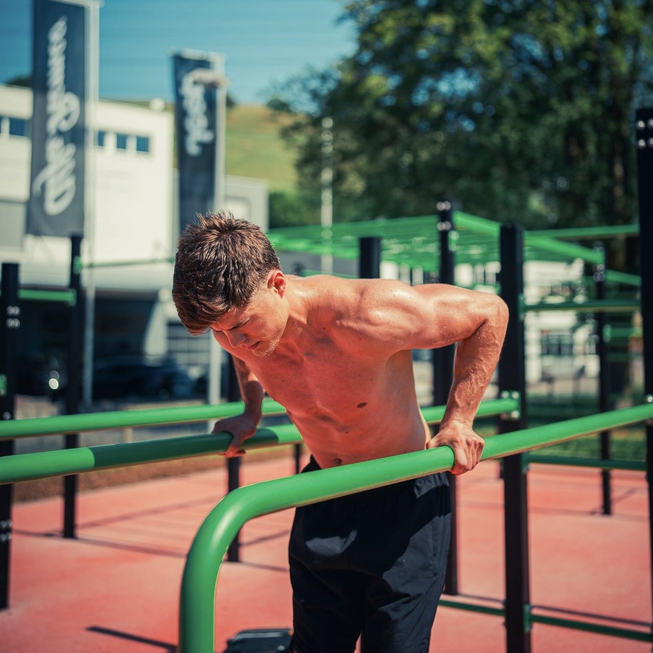 Sportler bei Calisthenics-Uebung im Freien